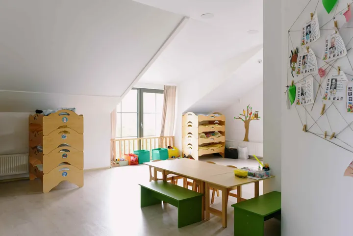 A bright daycare room with cubbies and a low activity table