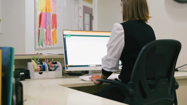 A director working at a desktop computer in the center office