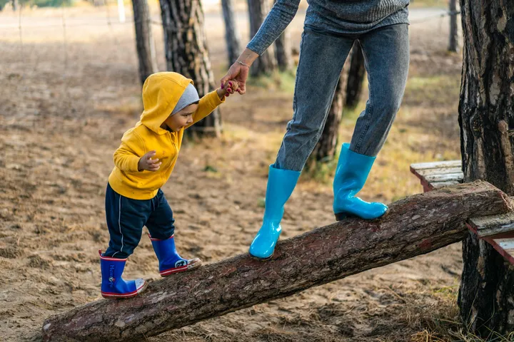 Children balancing along a log during outdoor play