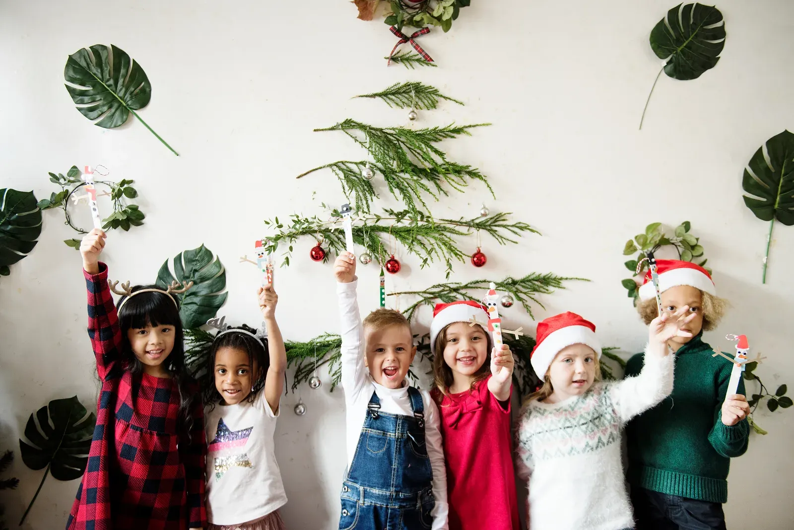kids at a child care center holding up their winter crafts.