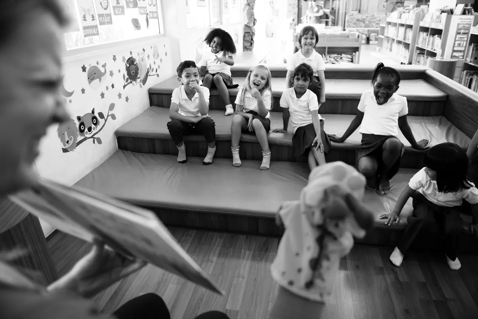 Kindergarten students sitting on the floor listening to story telling
