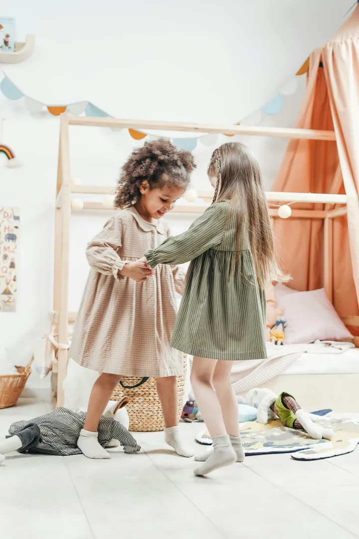 Two girls playing dress-up in a child care playroom