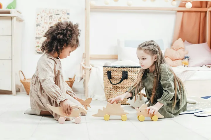 Two children building a tower with wooden blocks